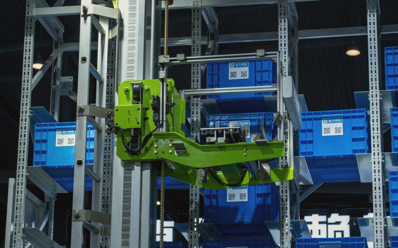 Automated storage and retrieval robot lifting crates on warehouse shelving racks